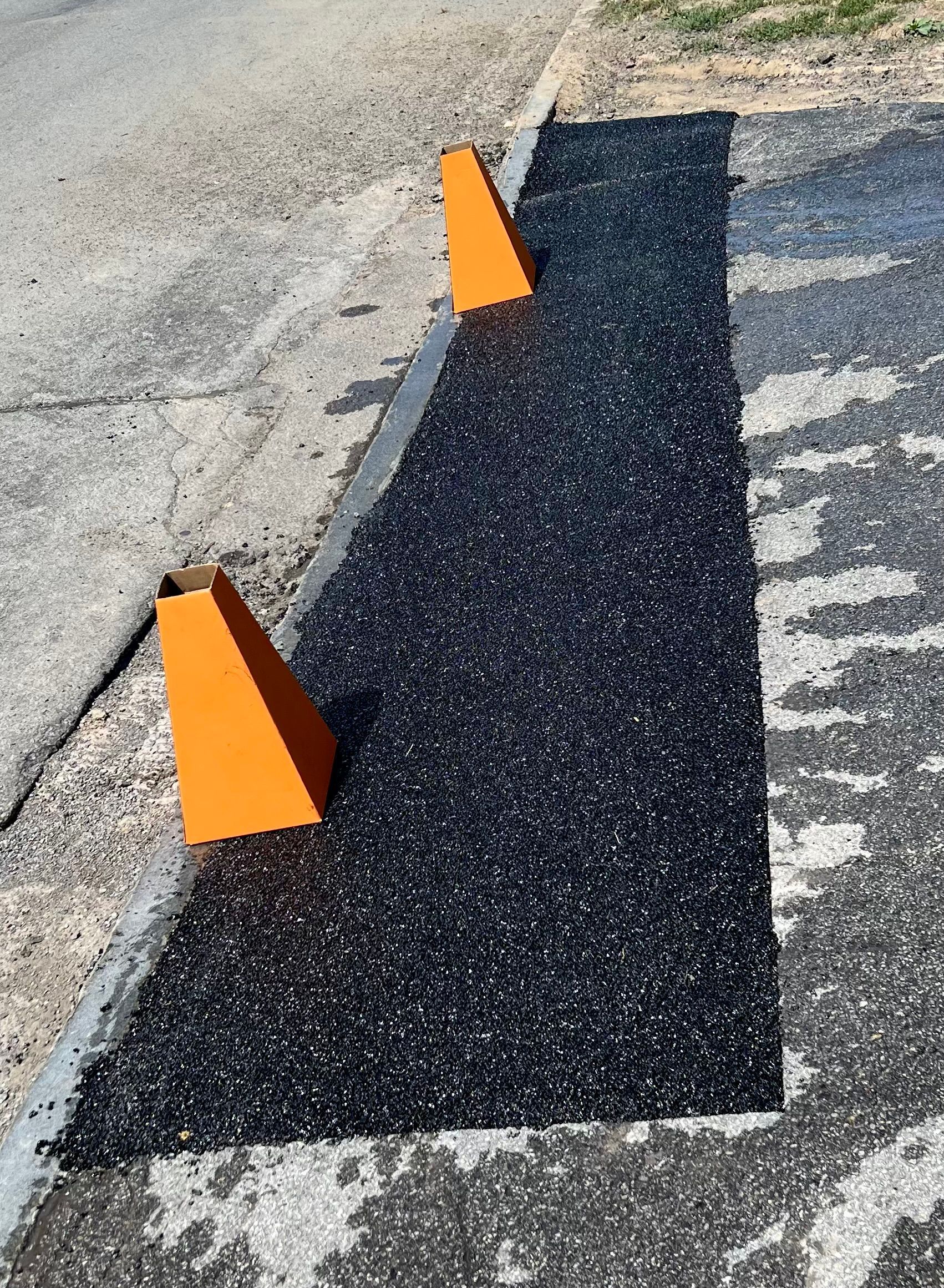 two orange cones are sitting on the side of a road
