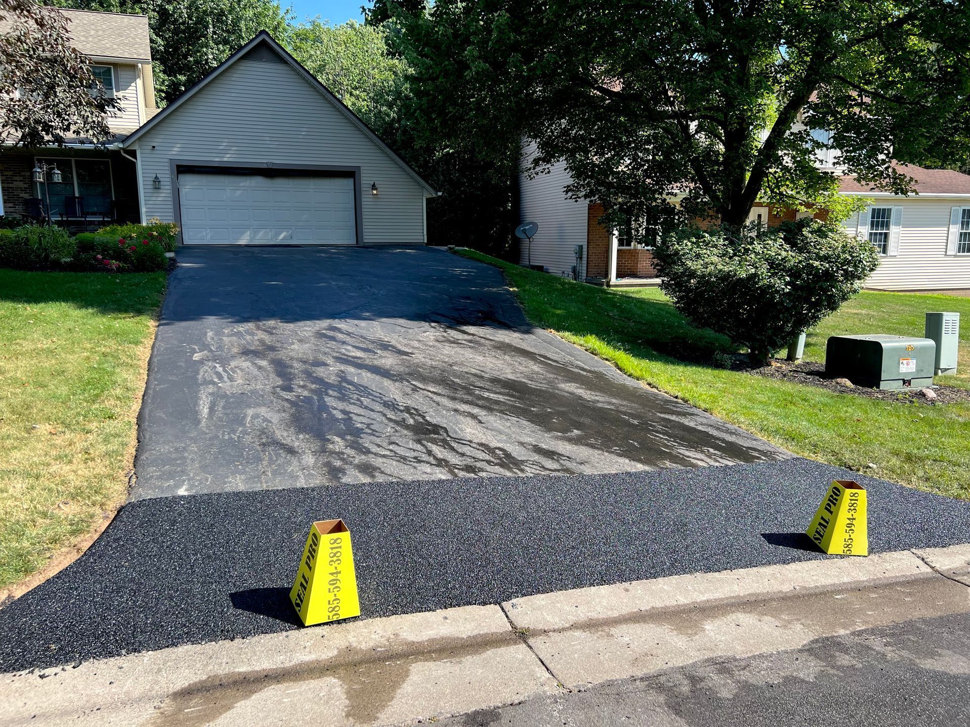 a driveway with two yellow caution cones in front of a house