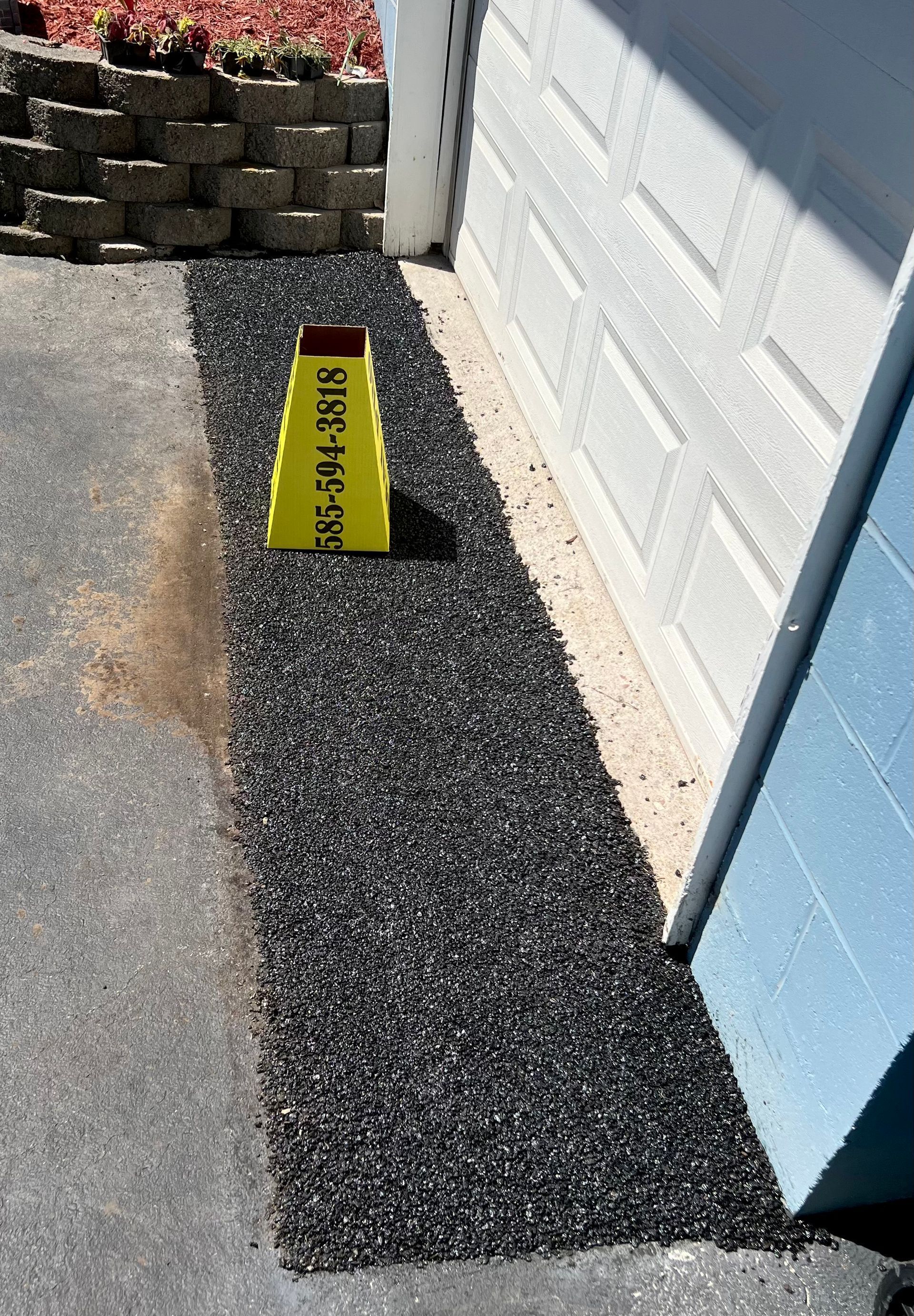 a yellow cone with a phone number on it