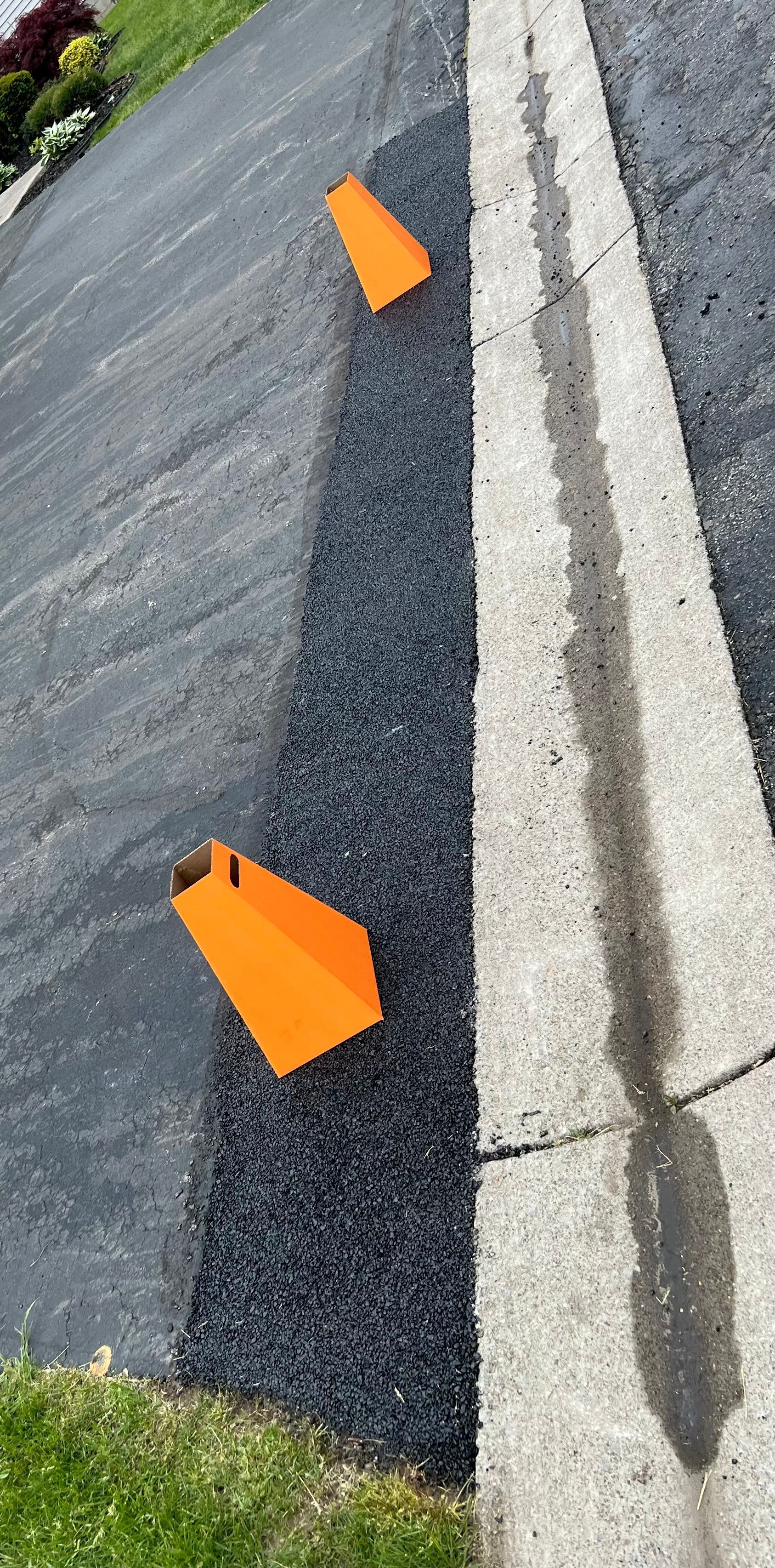 two orange cones are sitting on the side of a road