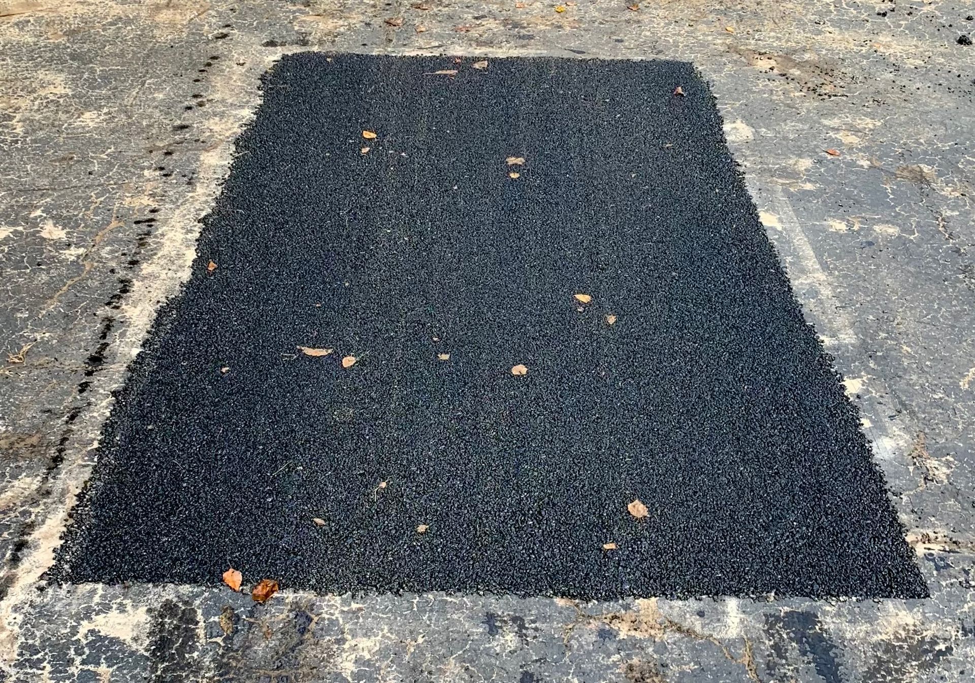 a piece of black asphalt is sitting on the ground
