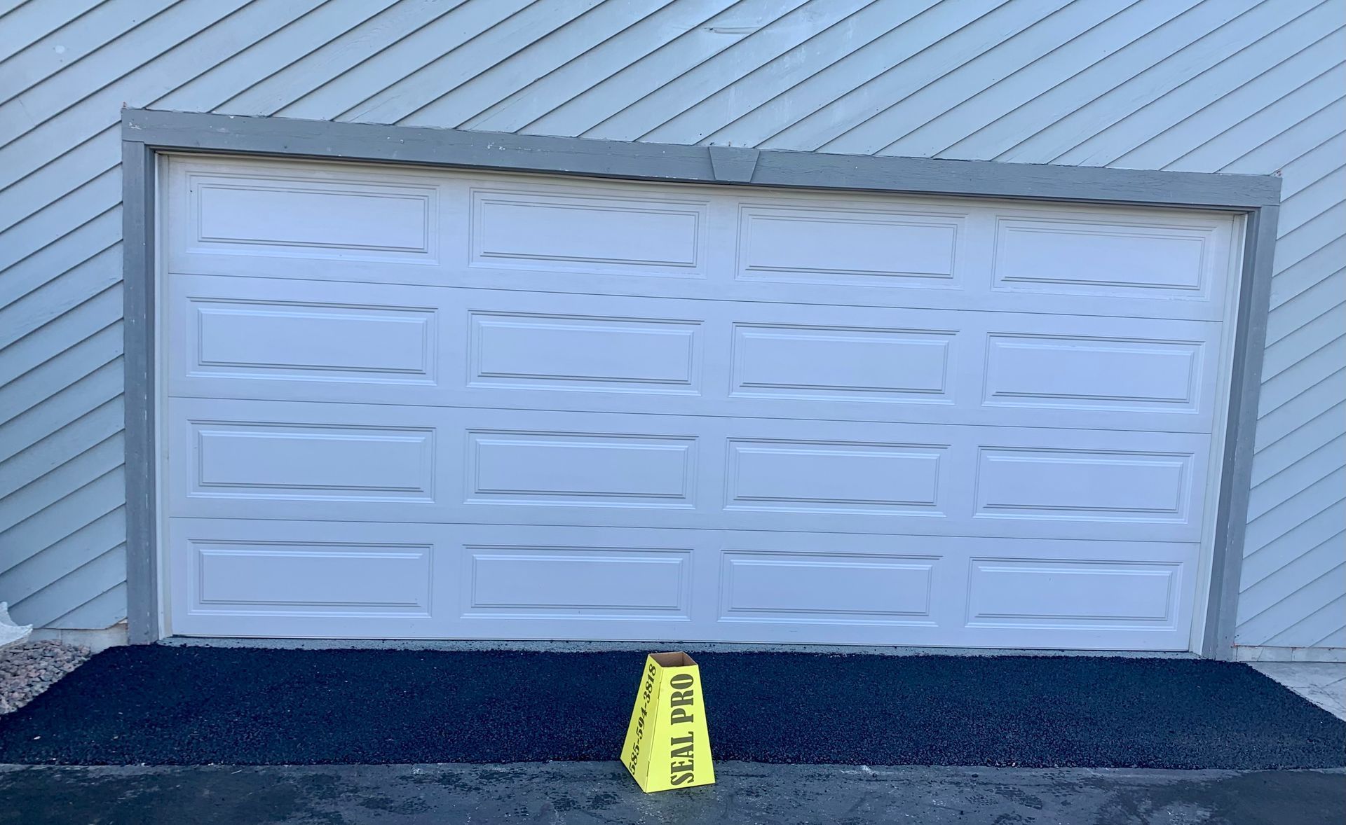 a white garage door with yellow caution tape on the ground in front of it