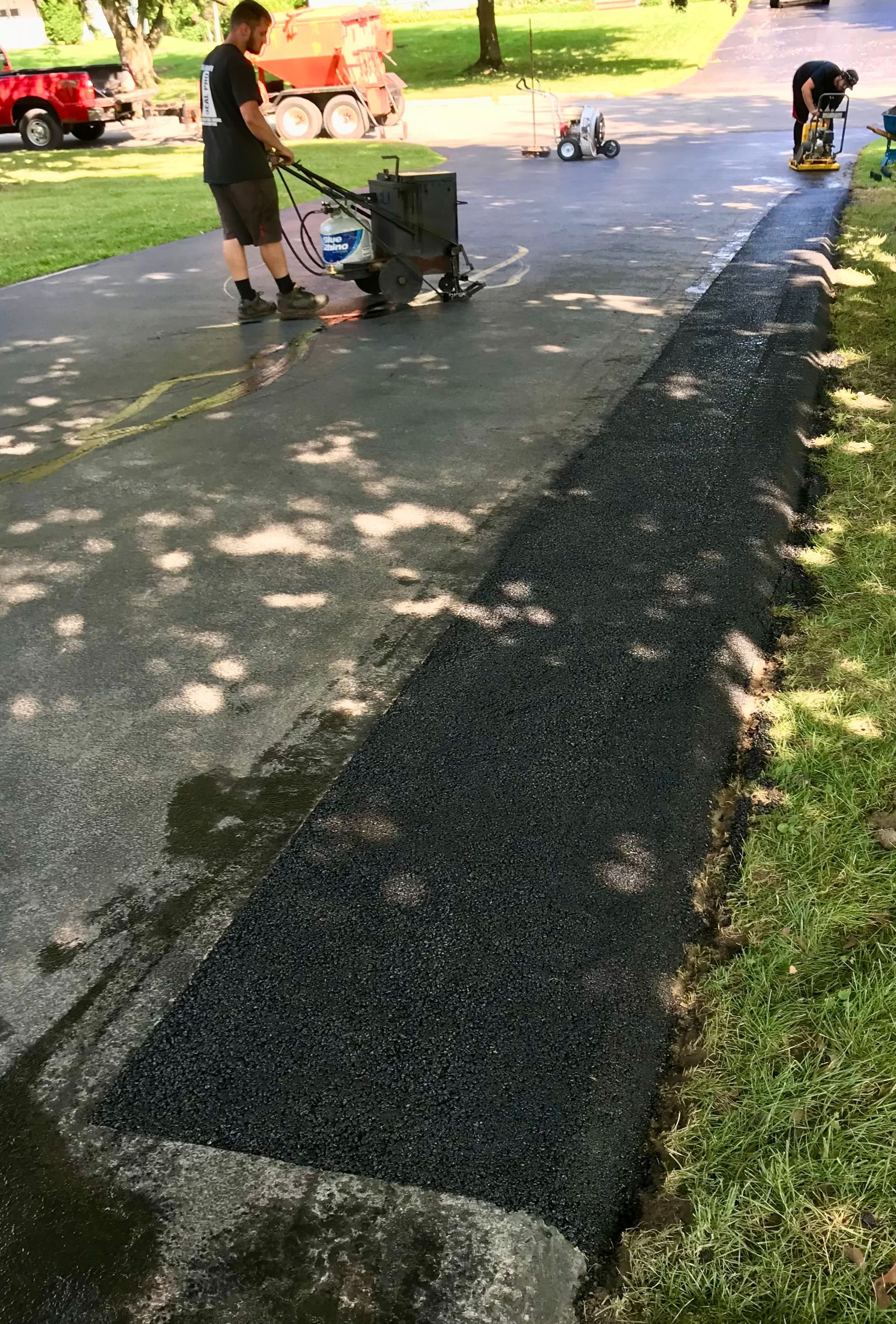 a man is using a vacuum cleaner to clean a driveway