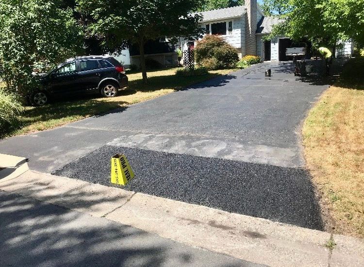 a black car is parked in the driveway of a house