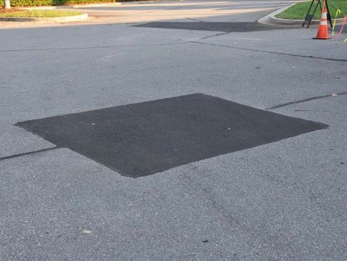 a large patch of asphalt on the side of a road