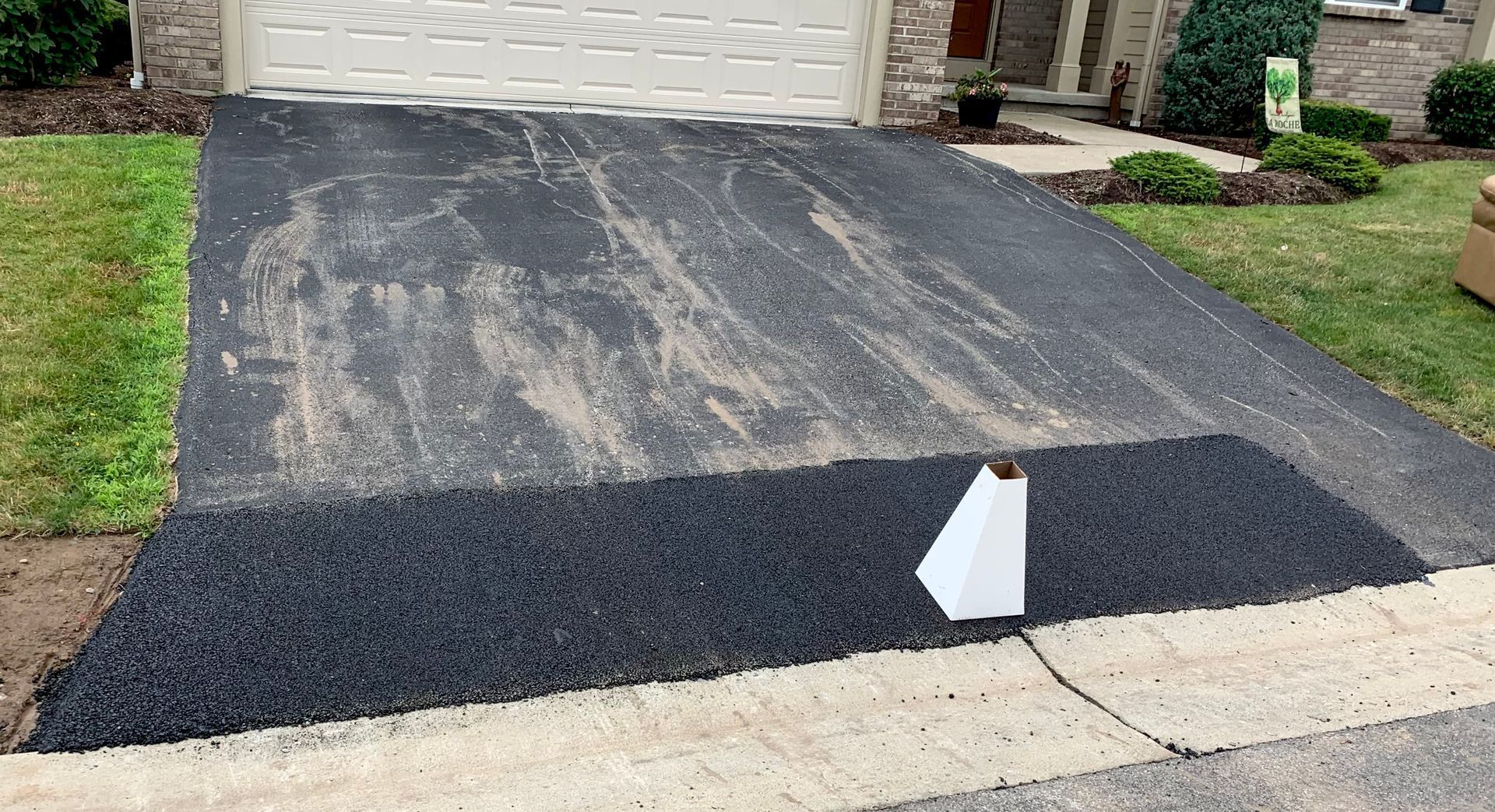 a black driveway with a white arrow pointing to the right