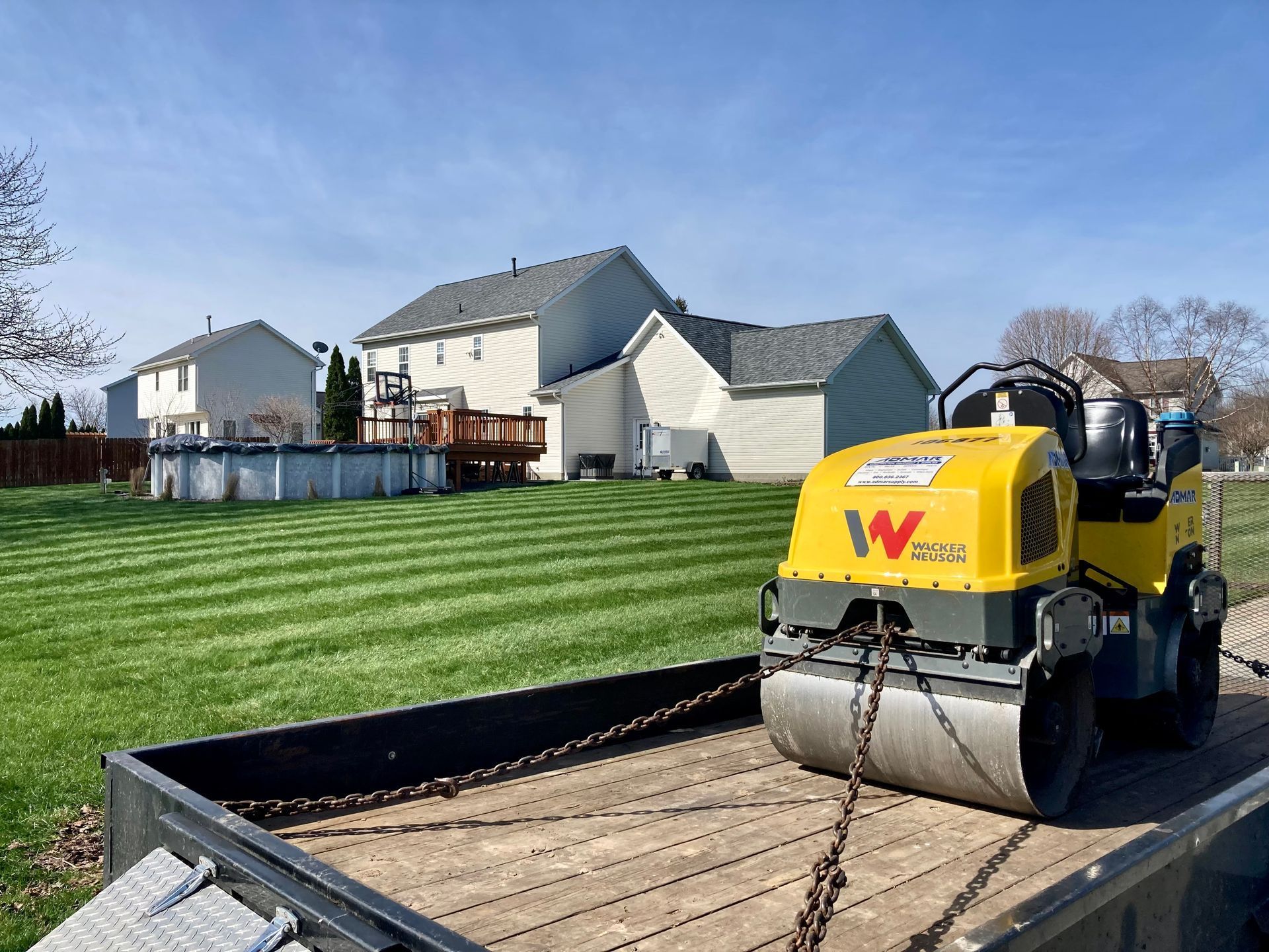 a yellow roller is sitting on top of a trailer