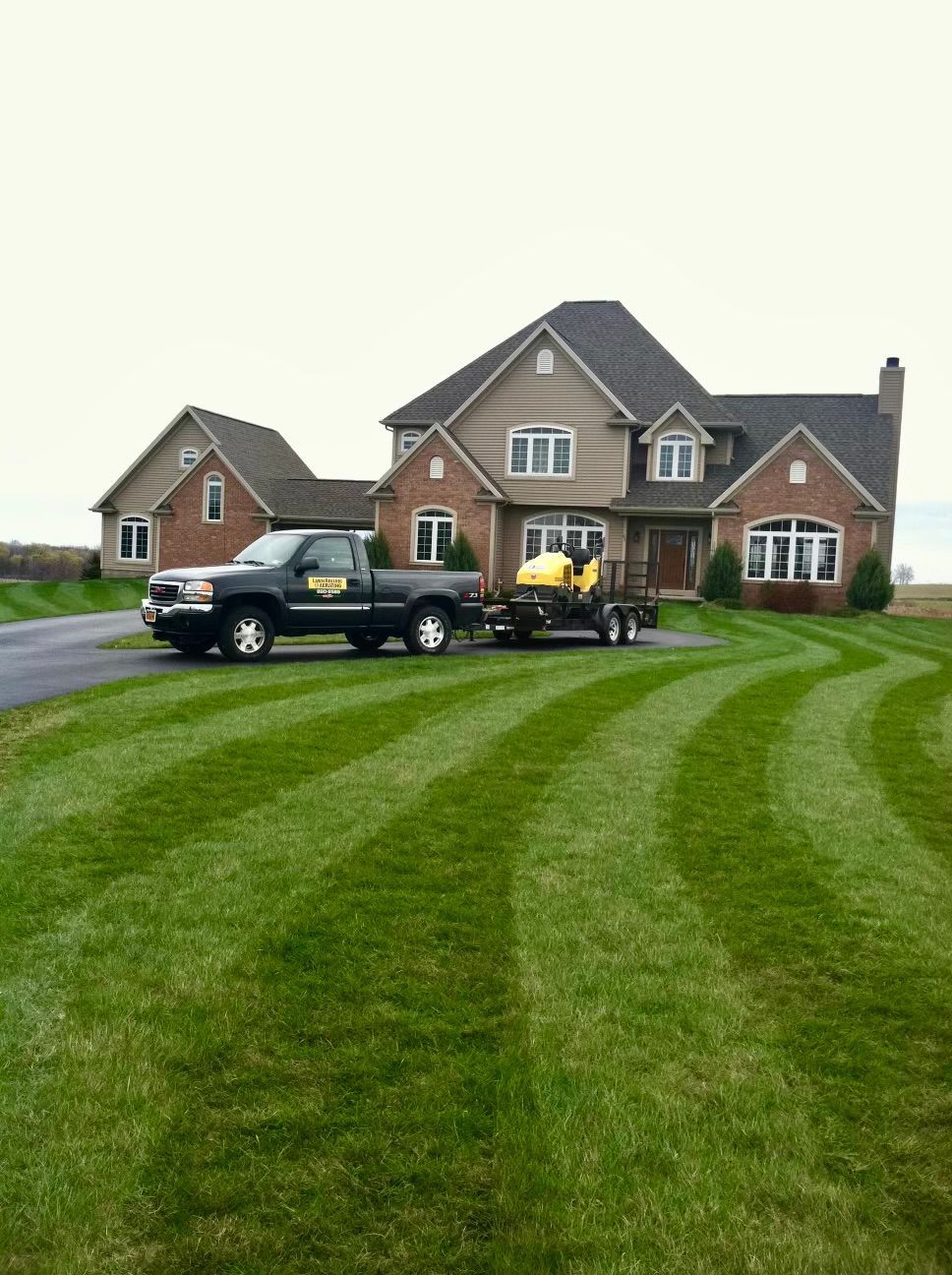a truck and a golf cart are parked in front of a large house