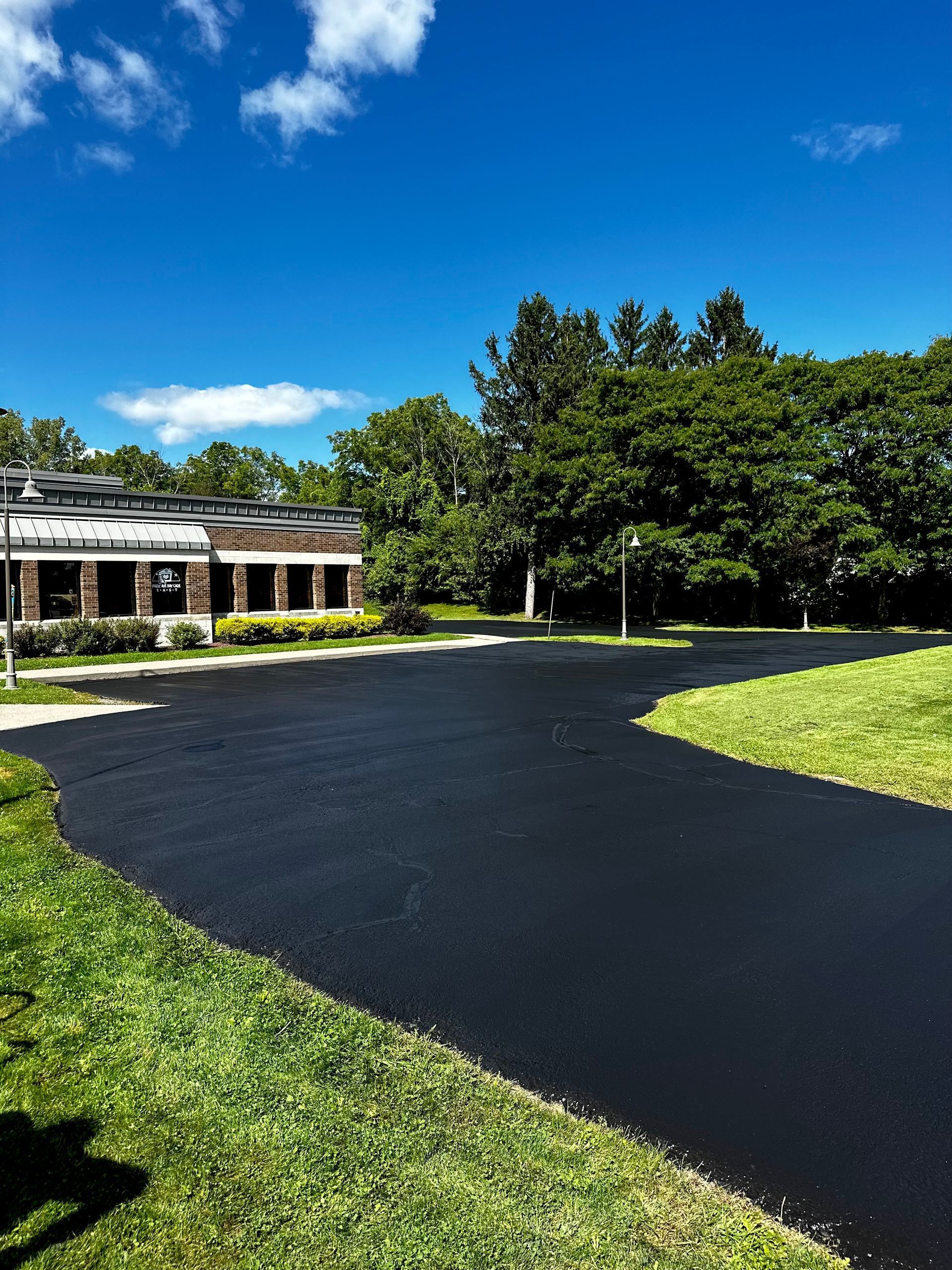 a black asphalt driveway leading to a large building