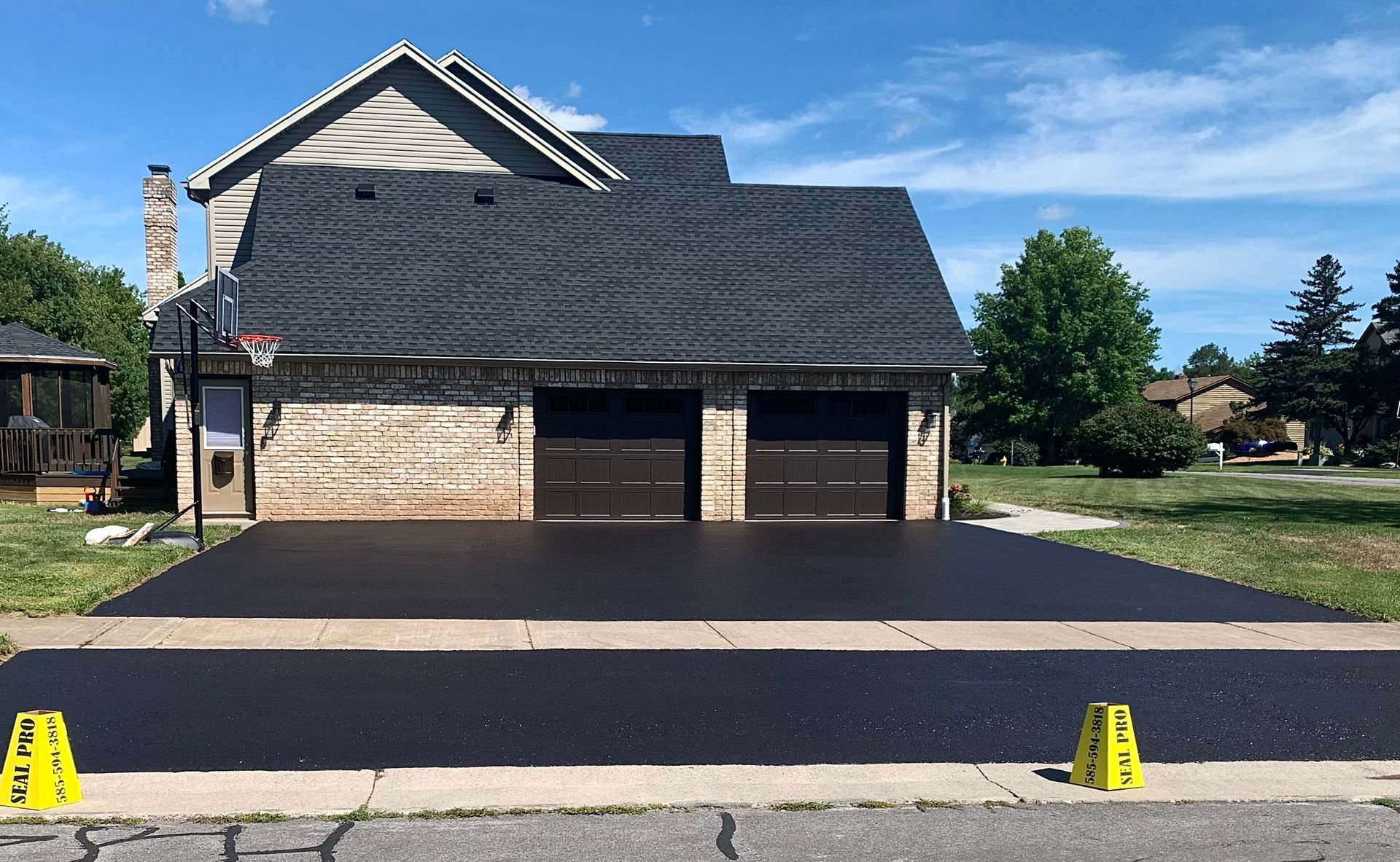 a house with a black roof and a black driveway