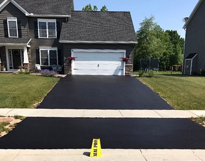 a house with a black driveway and a yellow sign that says road pro