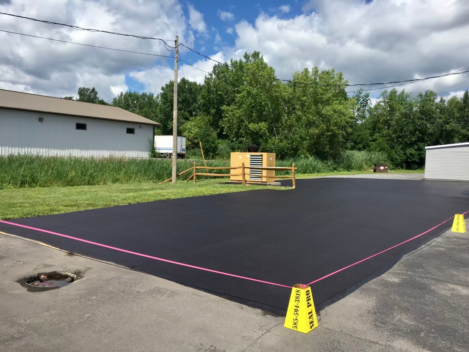 a parking lot with a fence and a building in the background