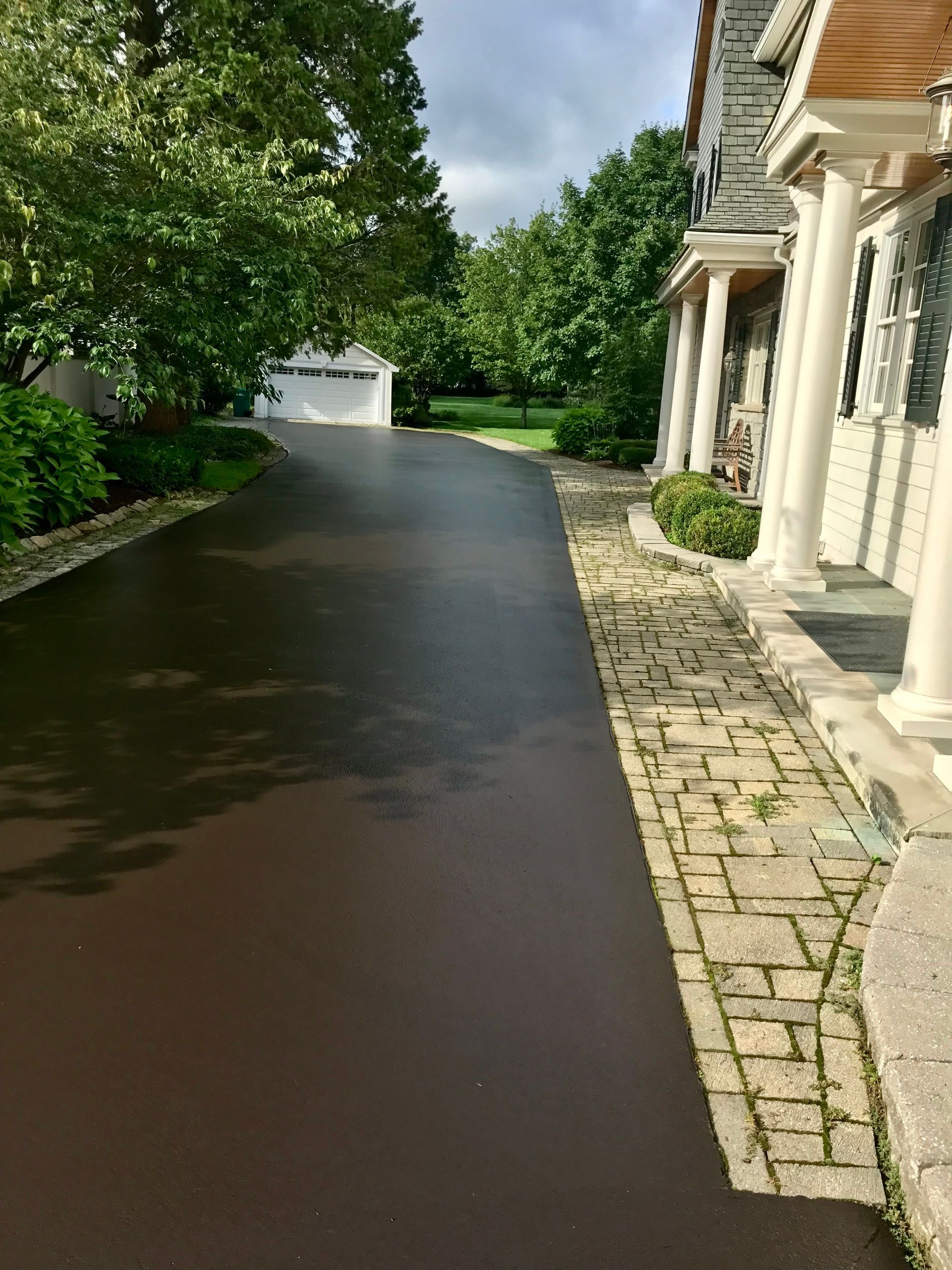 a driveway leading to a house with a brick walkway