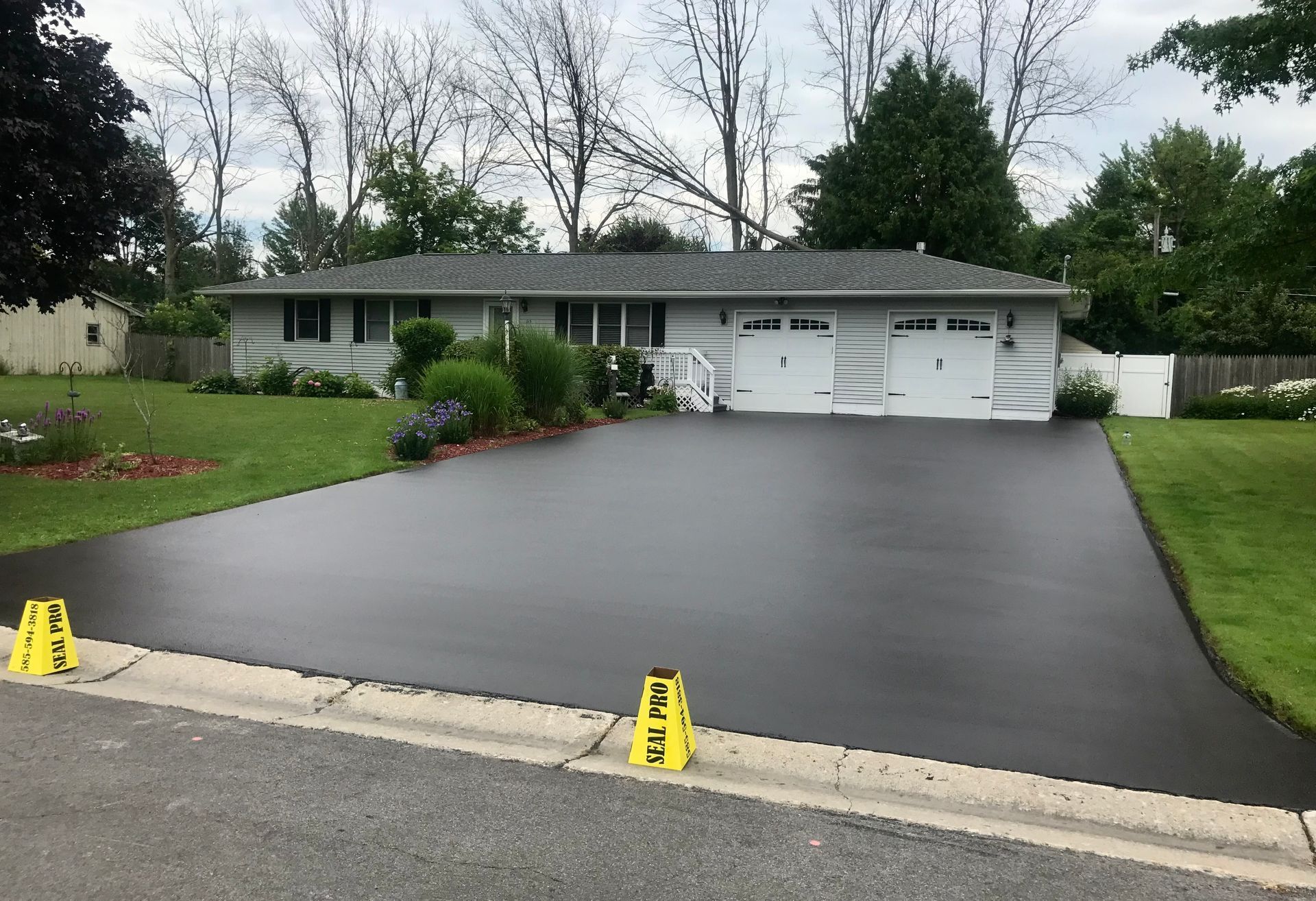 a house with a black driveway and yellow warning signs