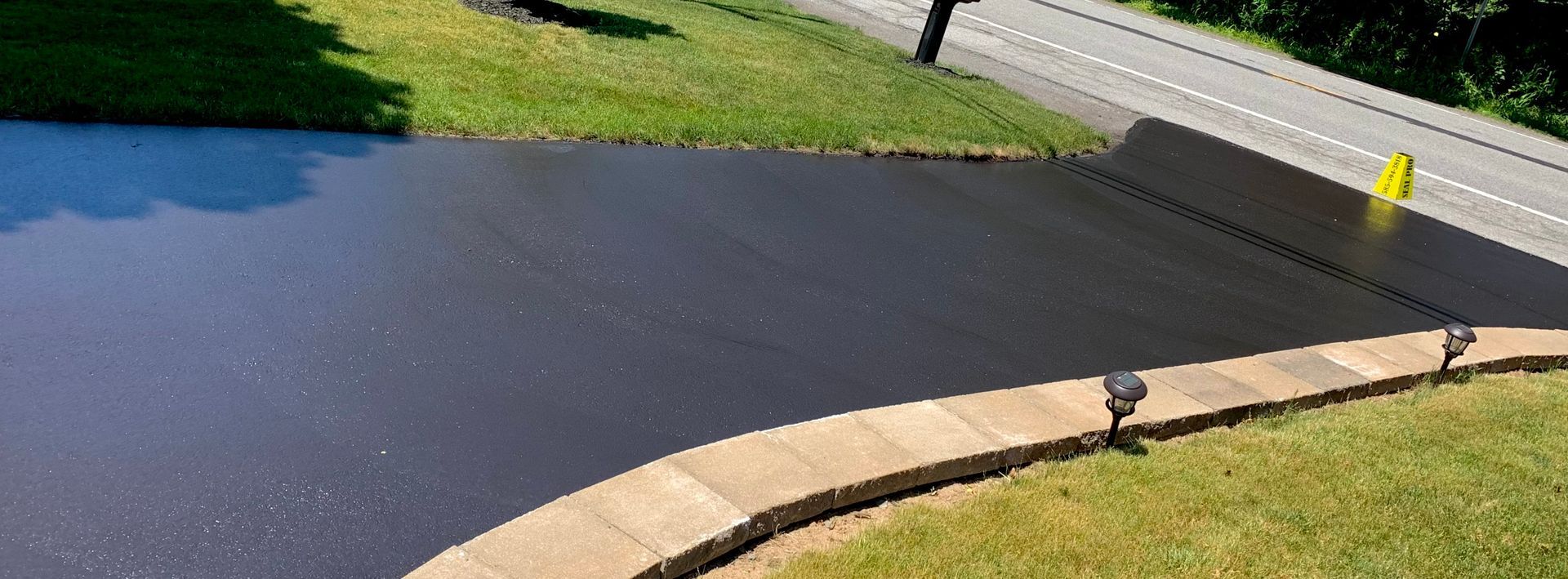 an aerial view of a pond surrounded by grass and a road