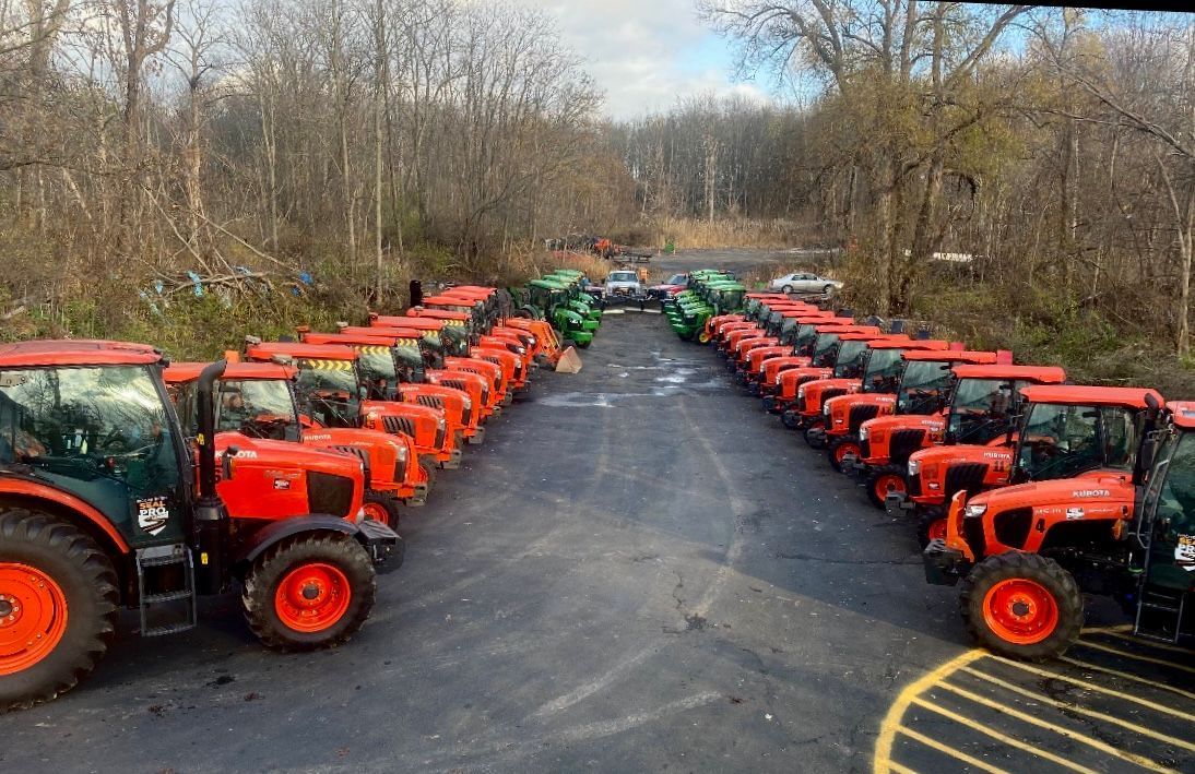 a lot of tractors are parked in a parking lot