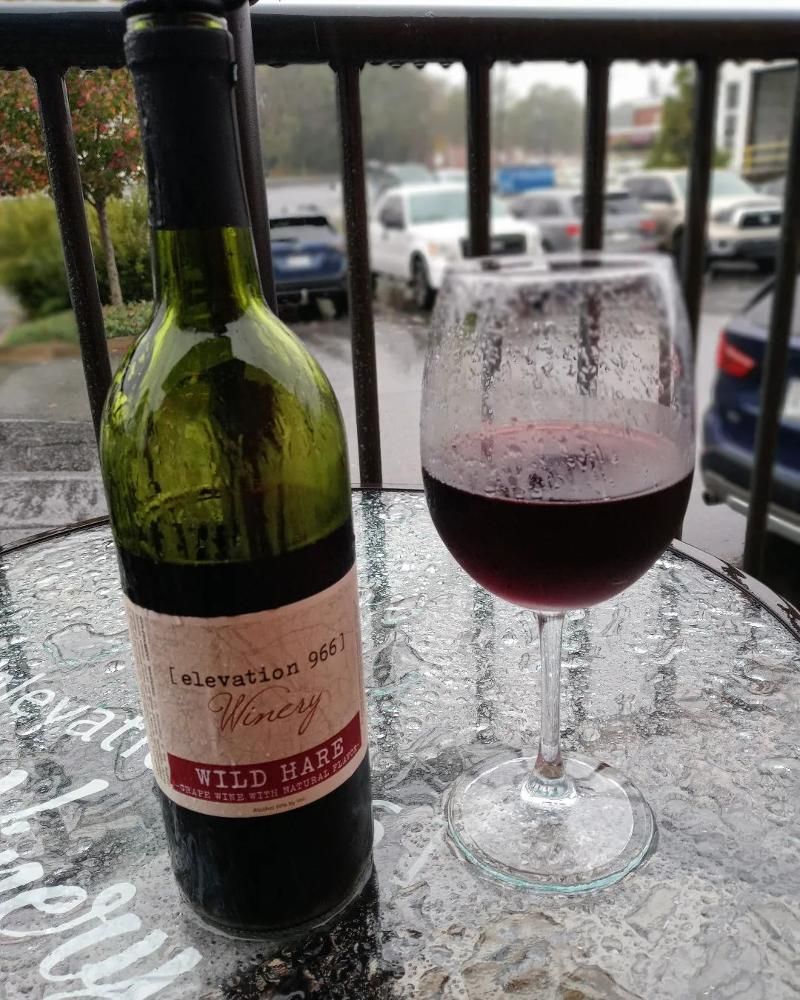 A bottle of wine and a glass of wine are on a table.