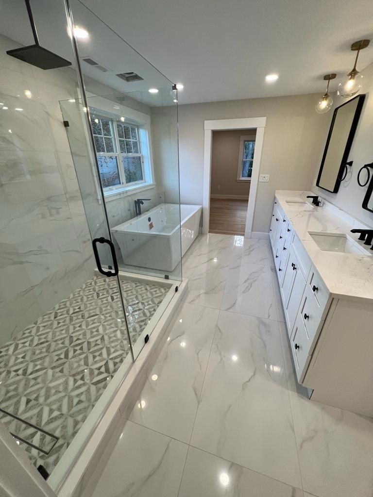 a bathroom with a bathtub, sinks, and a walk in shower