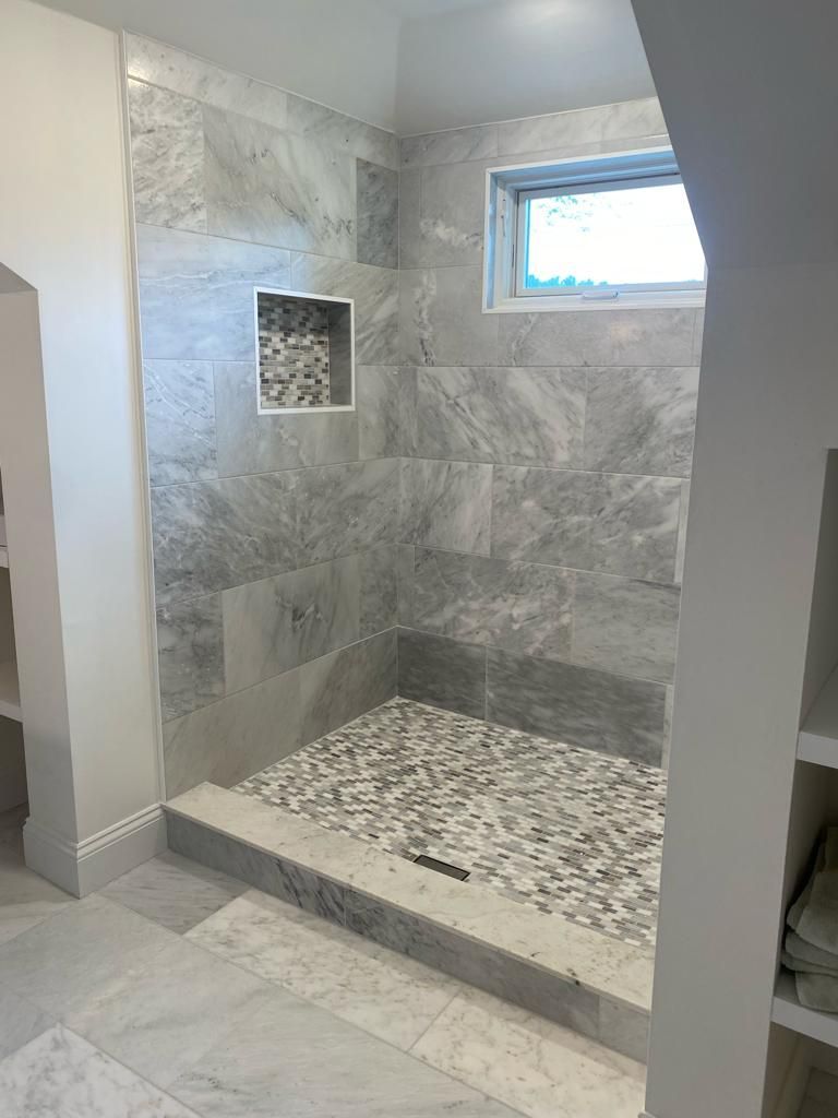 a bathroom with a walk in shower and a window