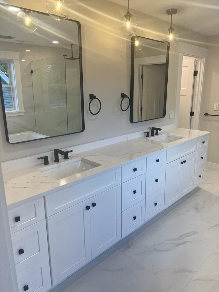 a bathroom with two sinks and two mirrors