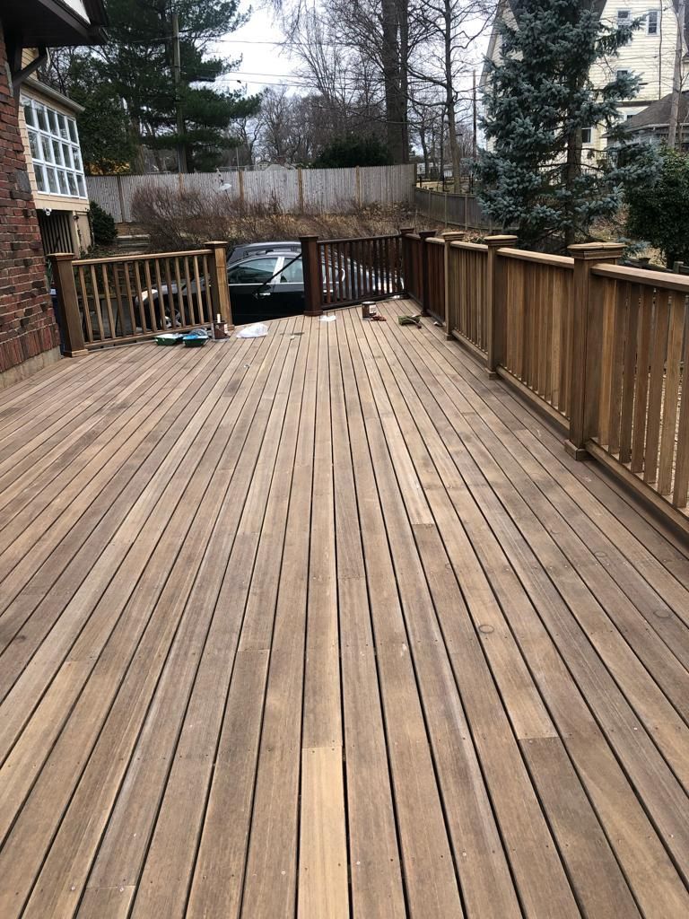 a wooden deck with a fence and a car parked on it