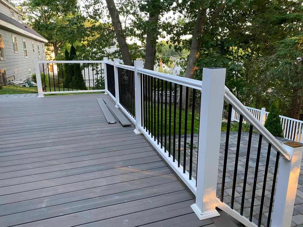 a deck with a white railing and stairs leading up to it