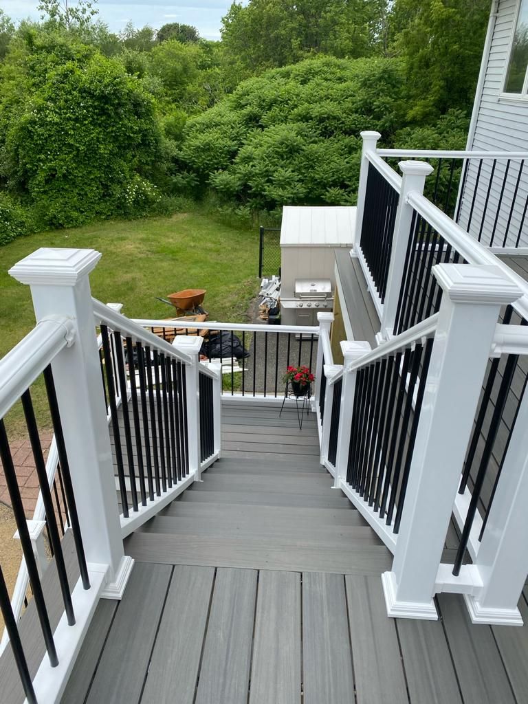 a deck with stairs leading up to it and a black railing