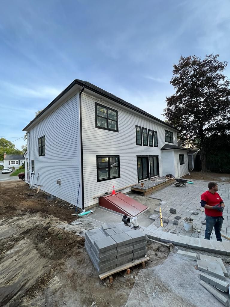 a man is standing in front of a large white house under construction