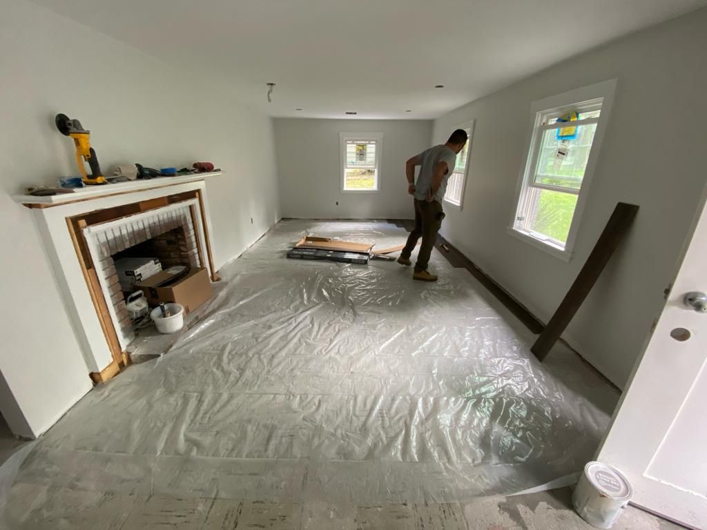 a man is standing in a living room covered in plastic