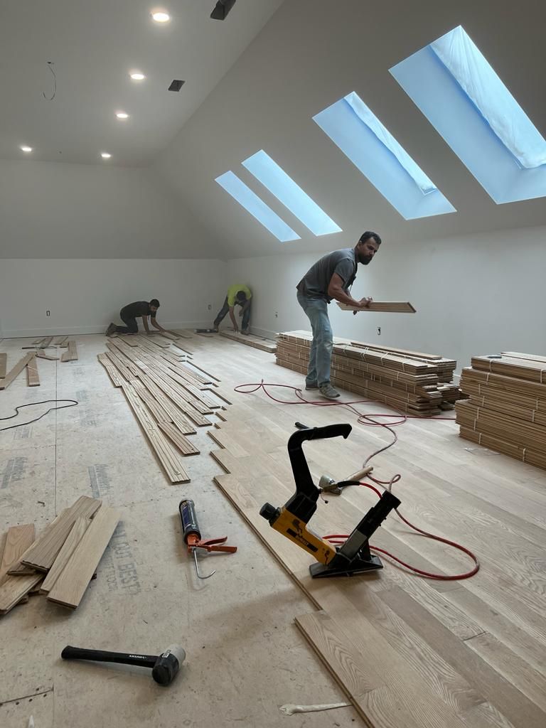 a group of men are working on a wooden floor