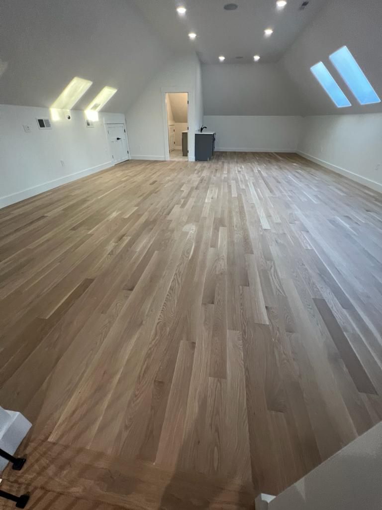 a large empty room with hardwood floors and white walls