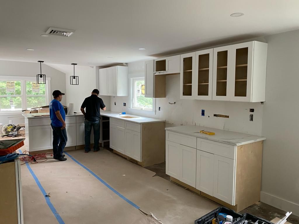 two men are working in a kitchen under construction