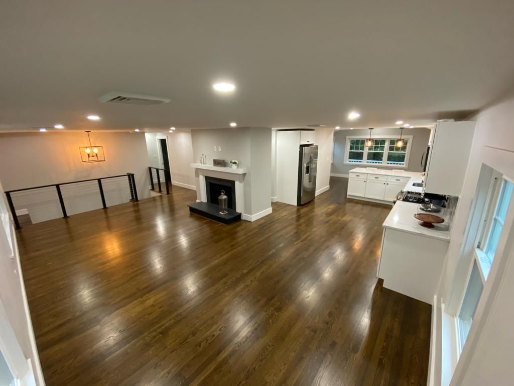a living room with hardwood floors and a fireplace in a house