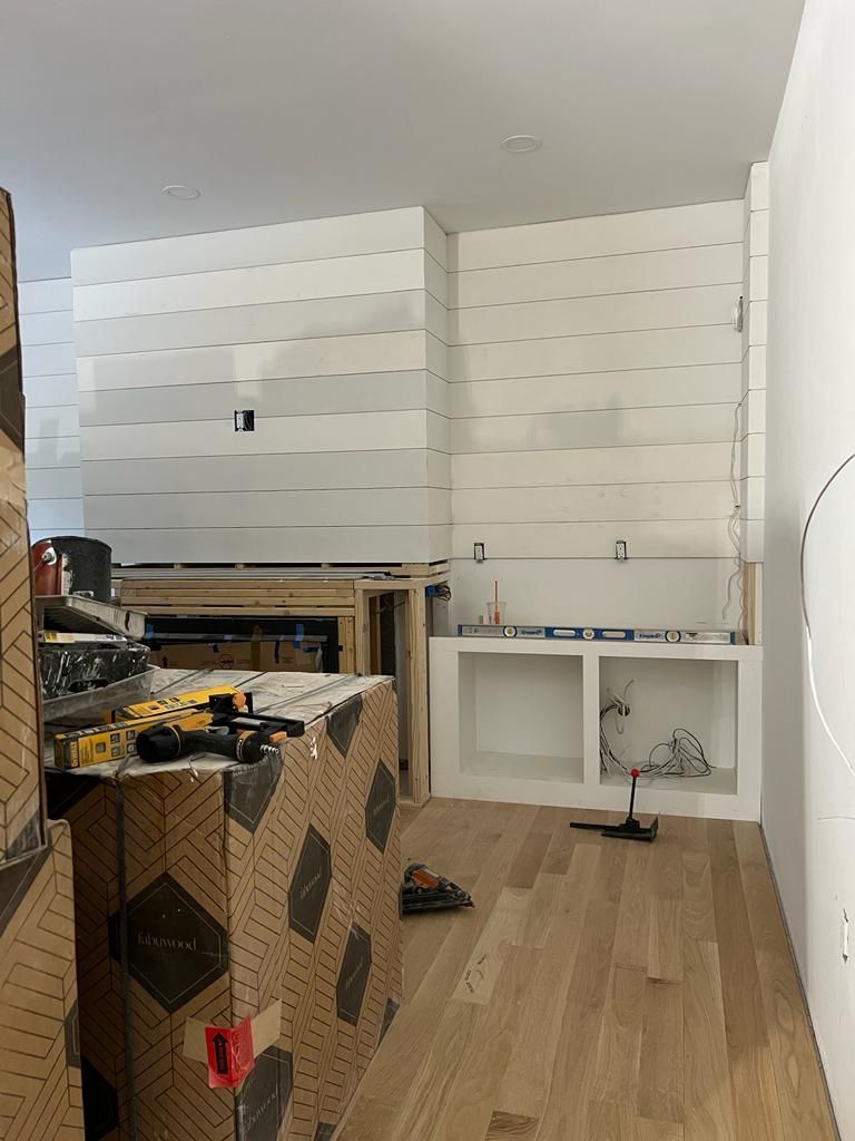 a room with wooden floors and white walls is being remodeled