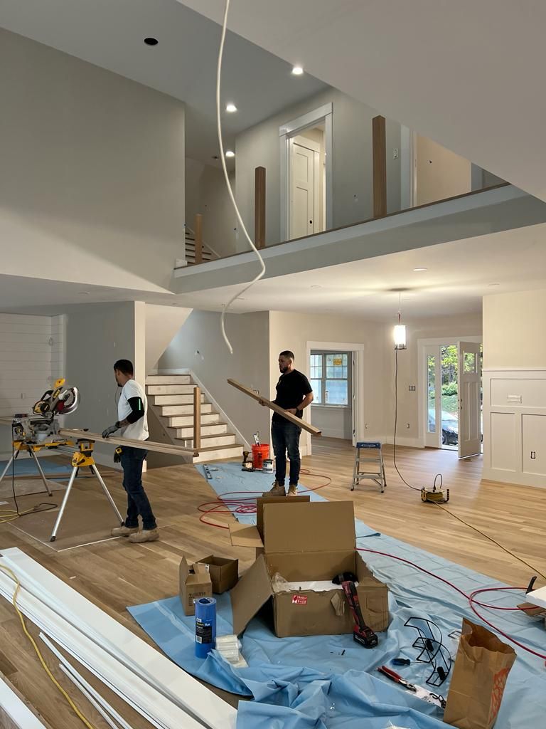 two men are working on a staircase in a house under construction