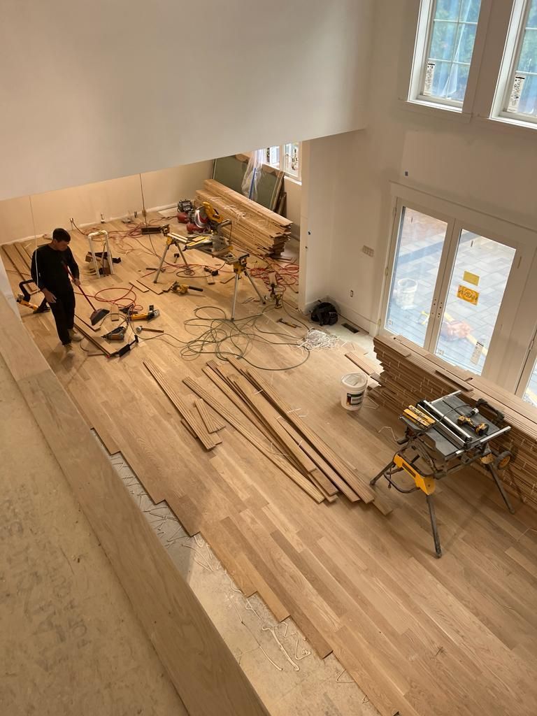 a man is standing on a wooden floor in a room