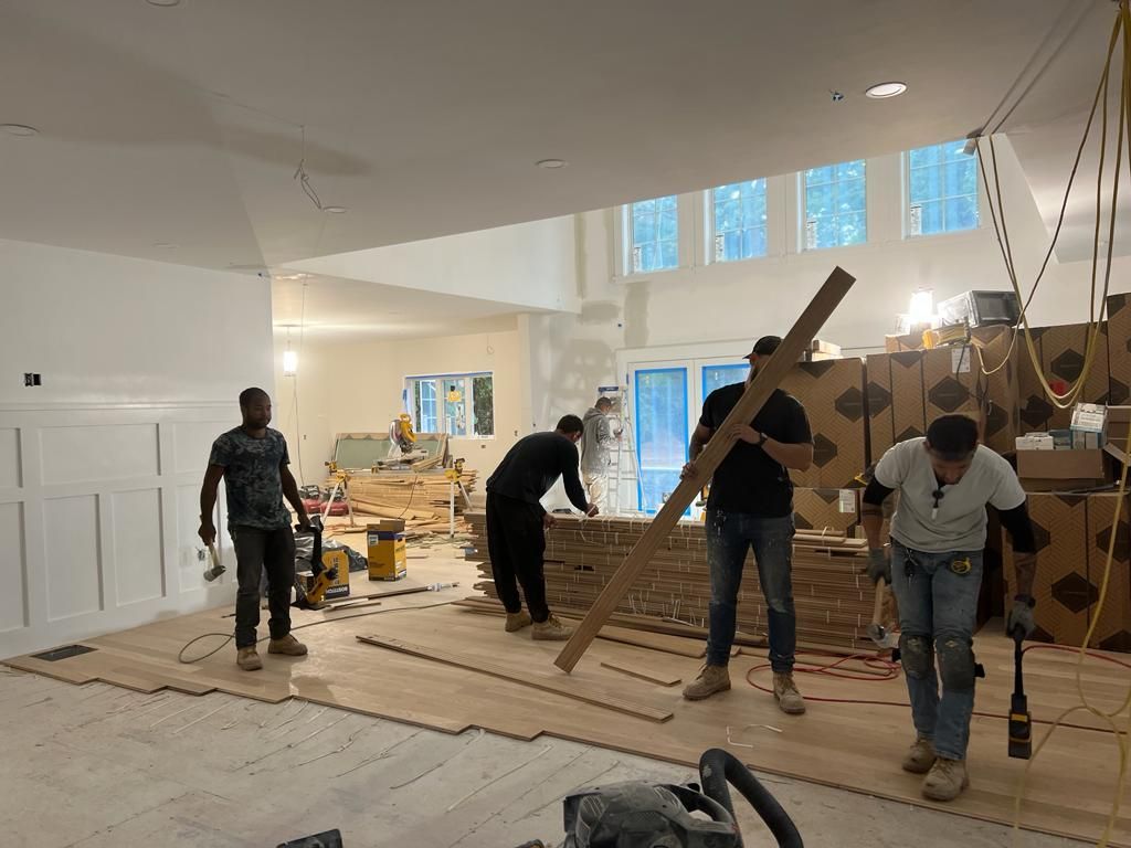 a group of men are working on a wooden floor in a room