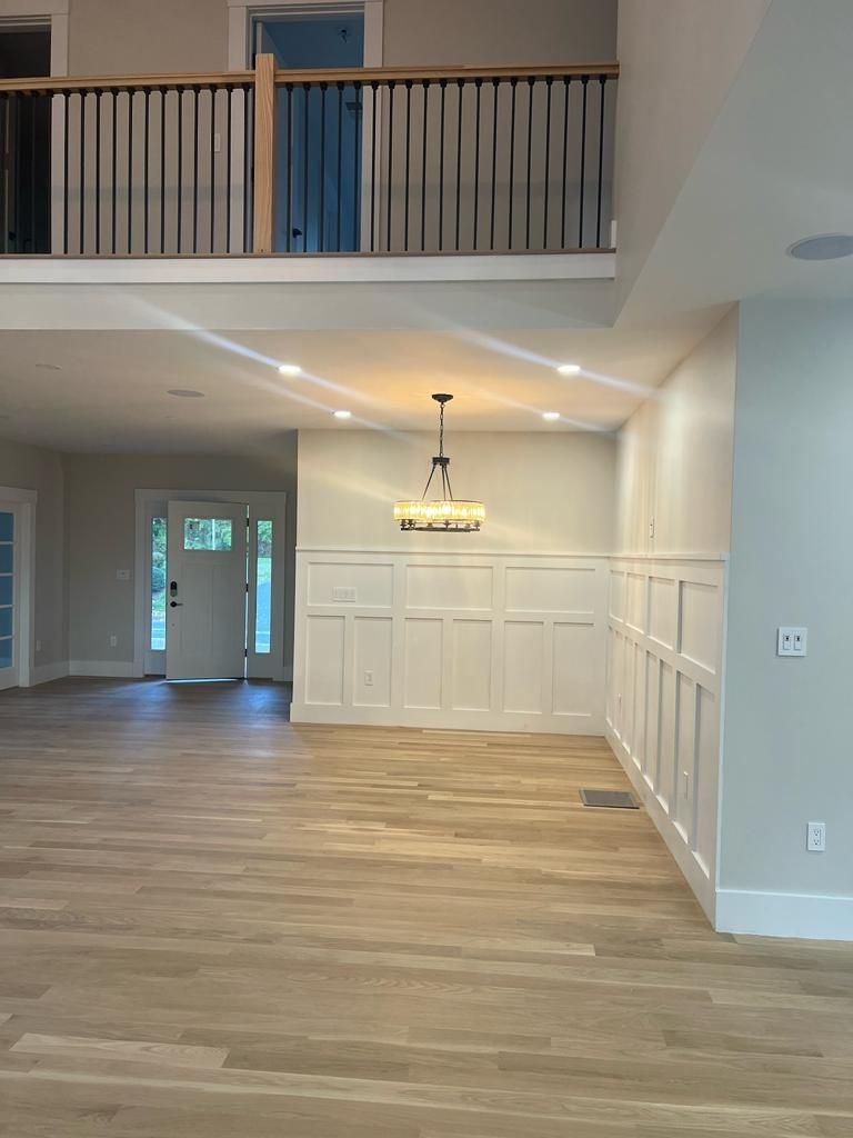 a large empty room with hardwood floors and a balcony