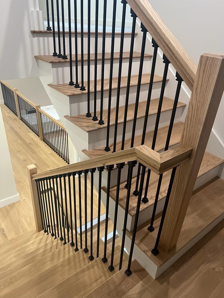 a wooden staircase with a black railing in a house