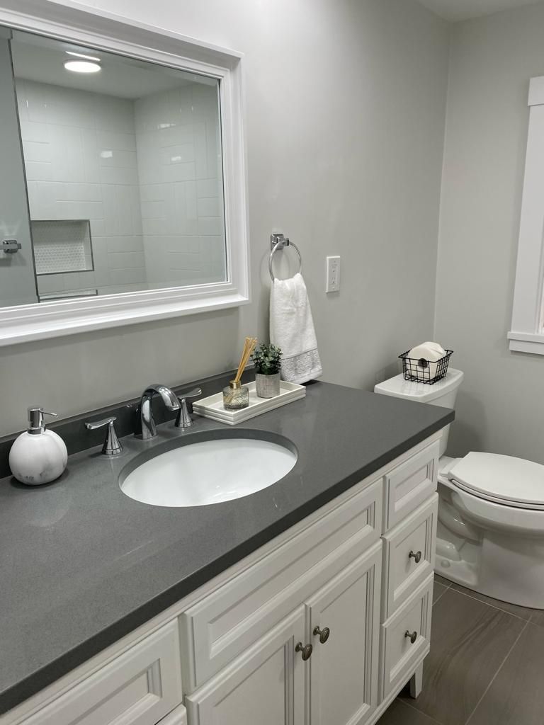 a bathroom with a sink, toilet and mirror