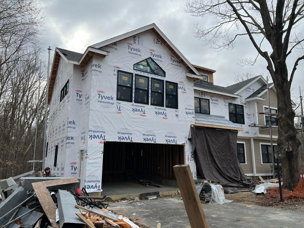 a house is being built with a lot of windows and a garage