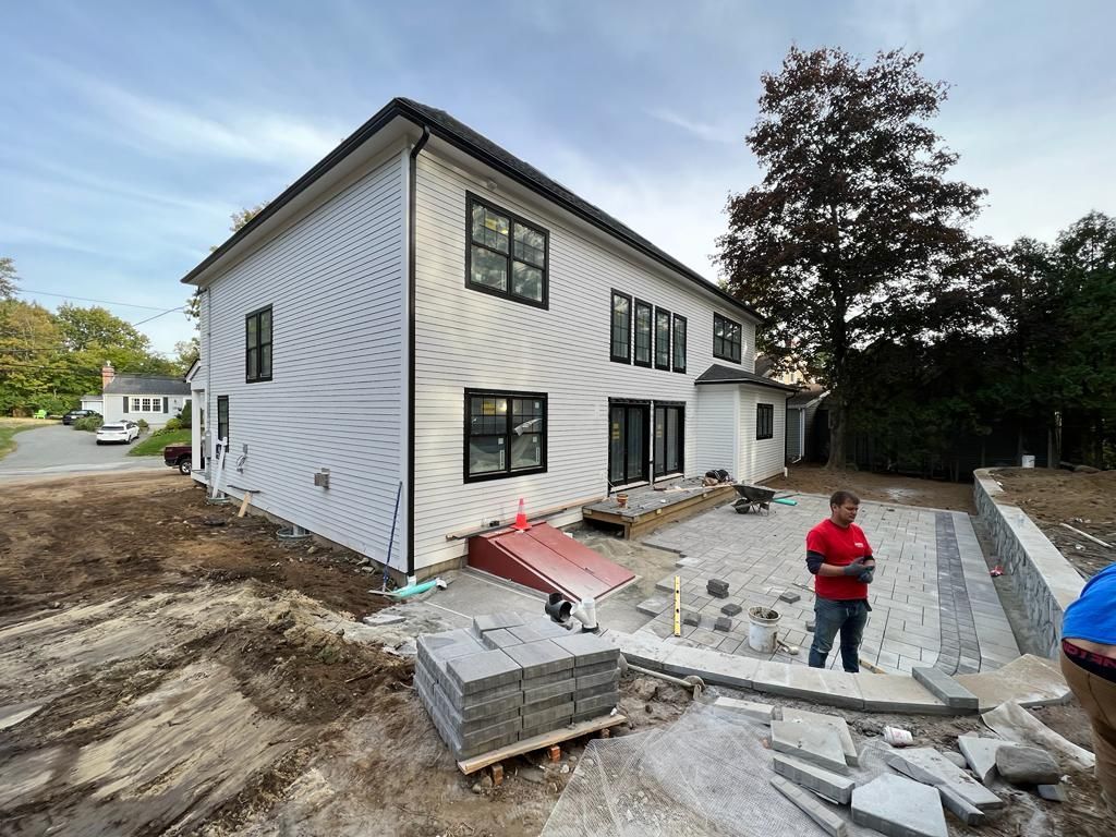 a man is standing in front of a large white house under construction