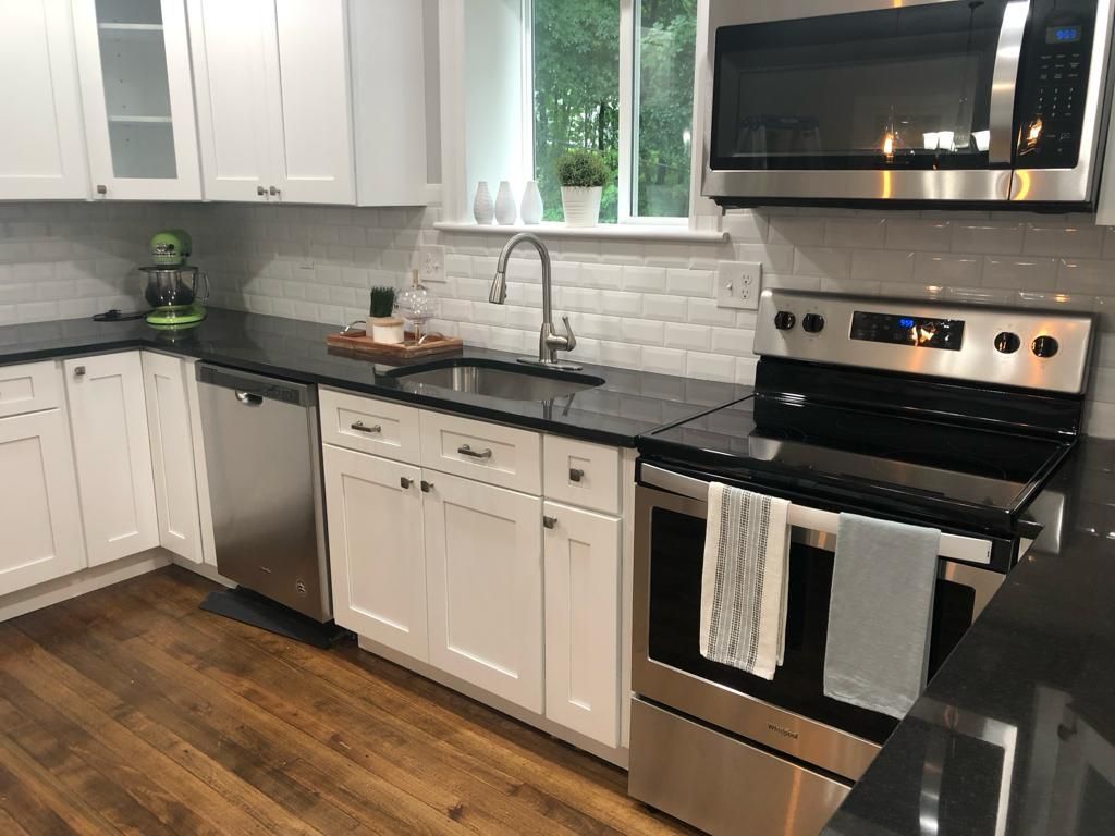 a kitchen with stainless steel appliances and white cabinets