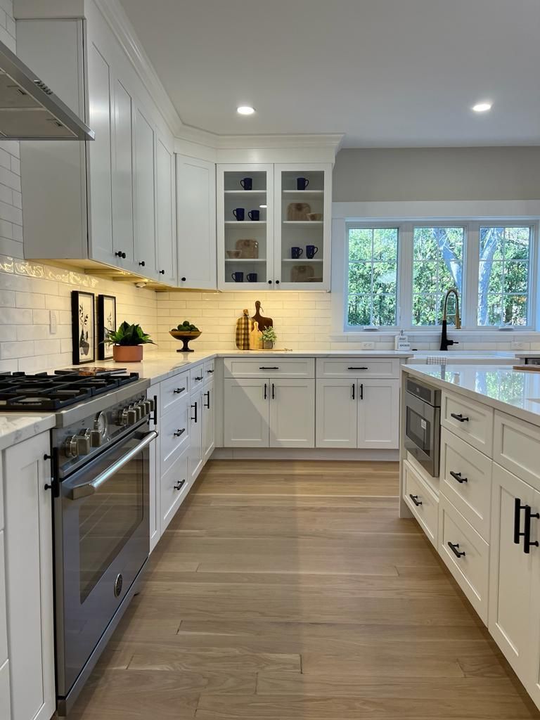 a kitchen with white cabinets and stainless steel appliances
