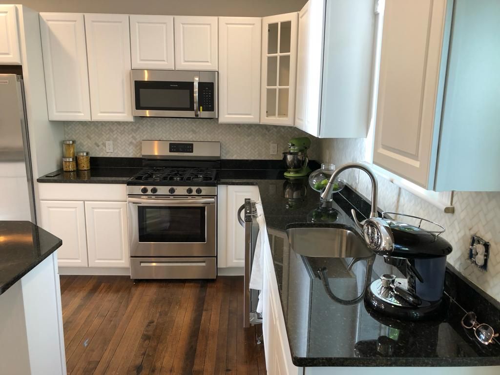 a kitchen with white cabinets and stainless steel appliances