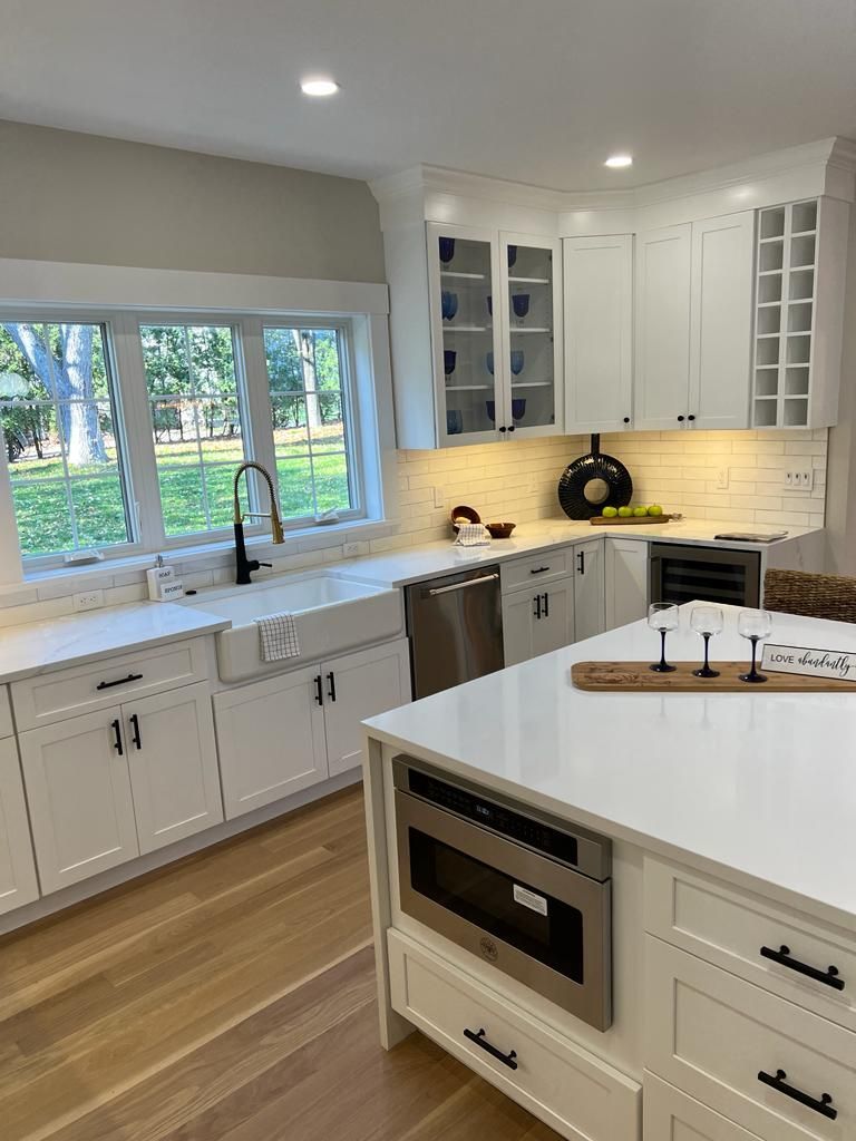 a kitchen with white cabinets, stainless steel appliances, and a large island