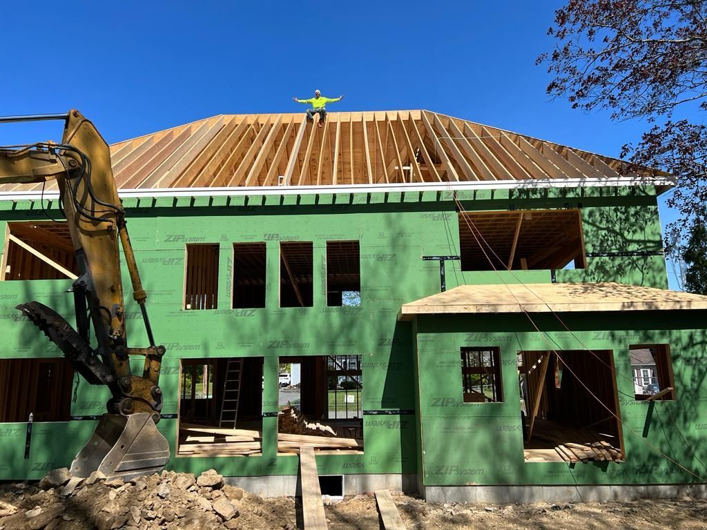 a man is standing on the roof of a house under construction