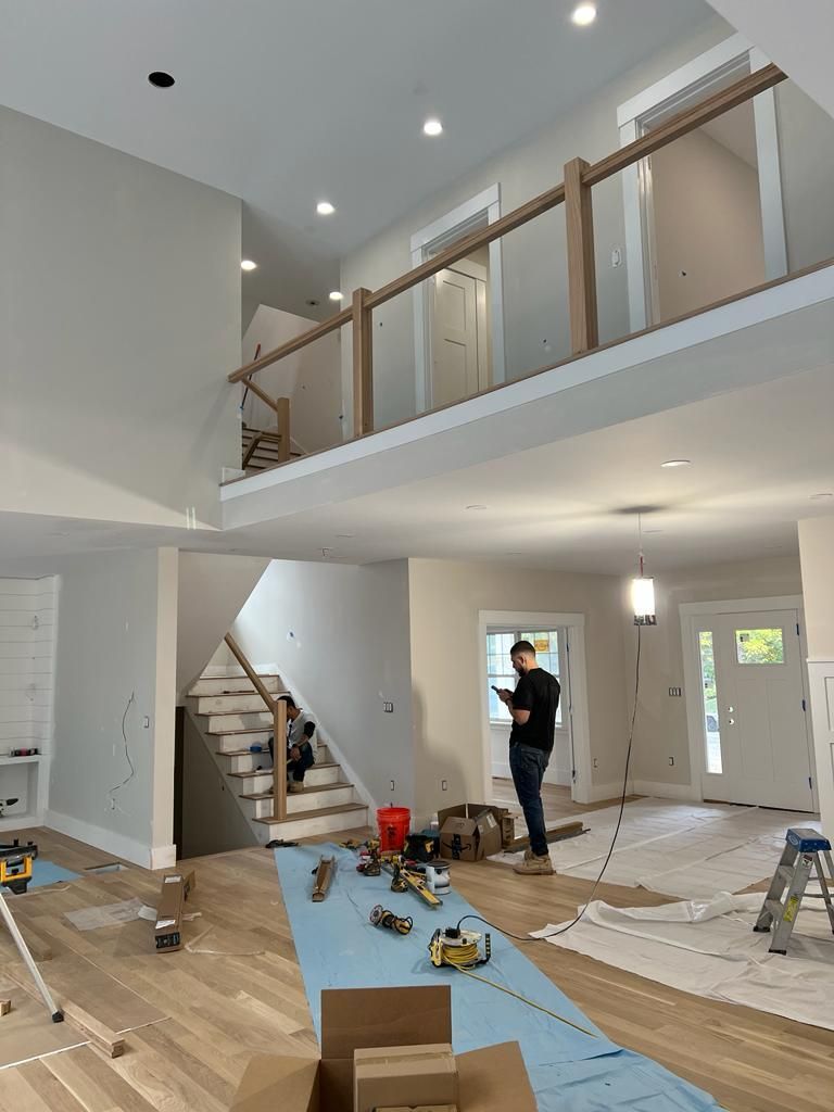 a man is standing in a large room with a staircase in the background