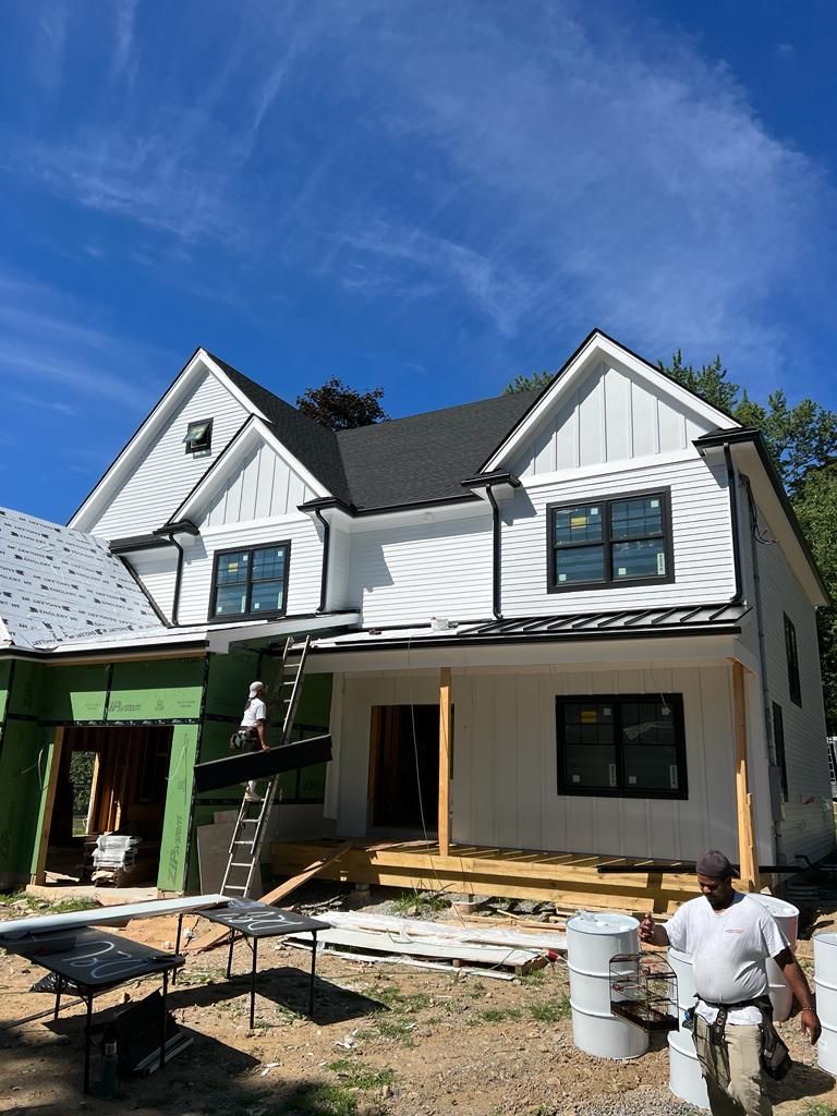 a man is standing in front of a house under construction