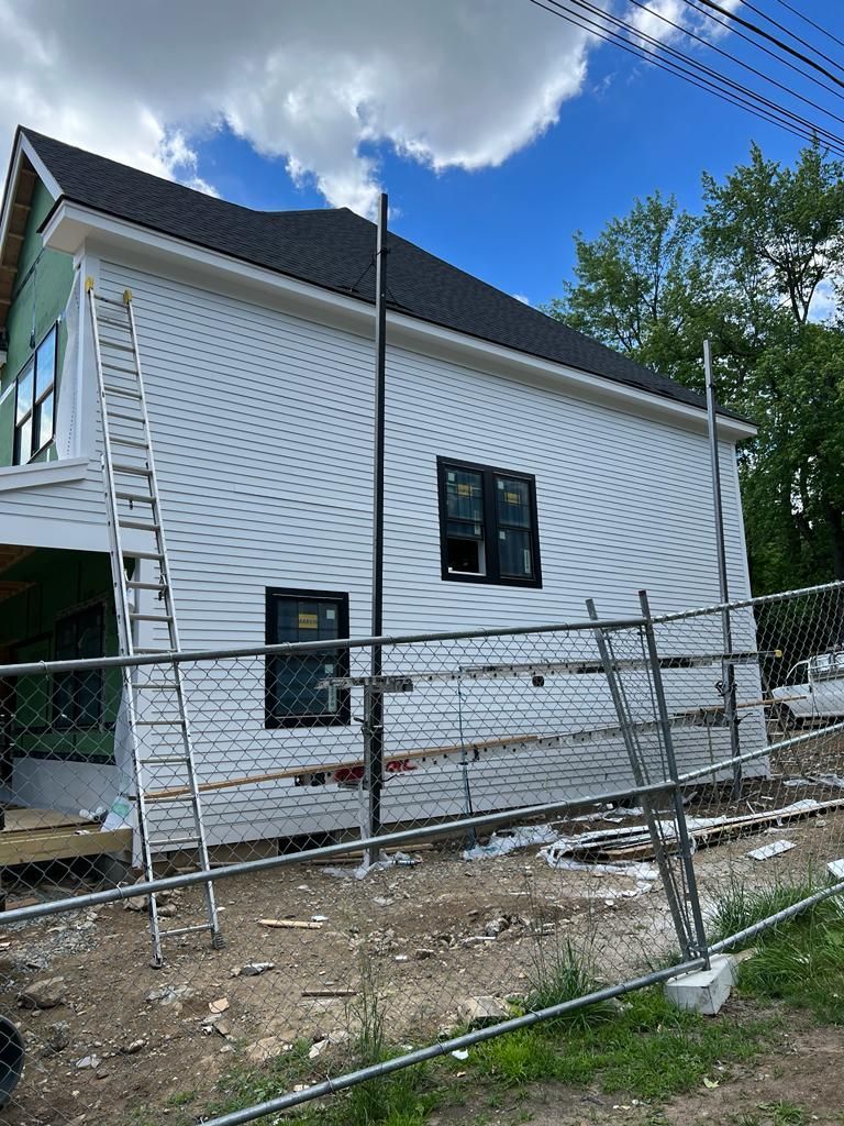 a white house is being built with a ladder on the side of it